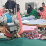 konveksi tangan pertama sedang memotong kain